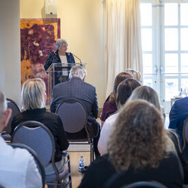 La gouverneure générale Mary Simon debout à un pupitre s'adressant à une salle remplie de personnes.