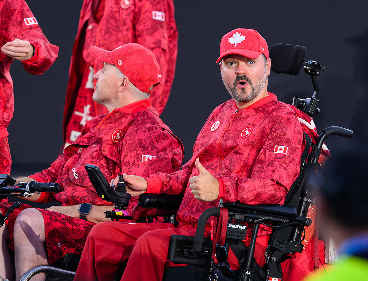 A Team Canada member in a wheelchair expressing their joy during the opening ceremonies of the 2024 Paralympic Games in Paris, France.