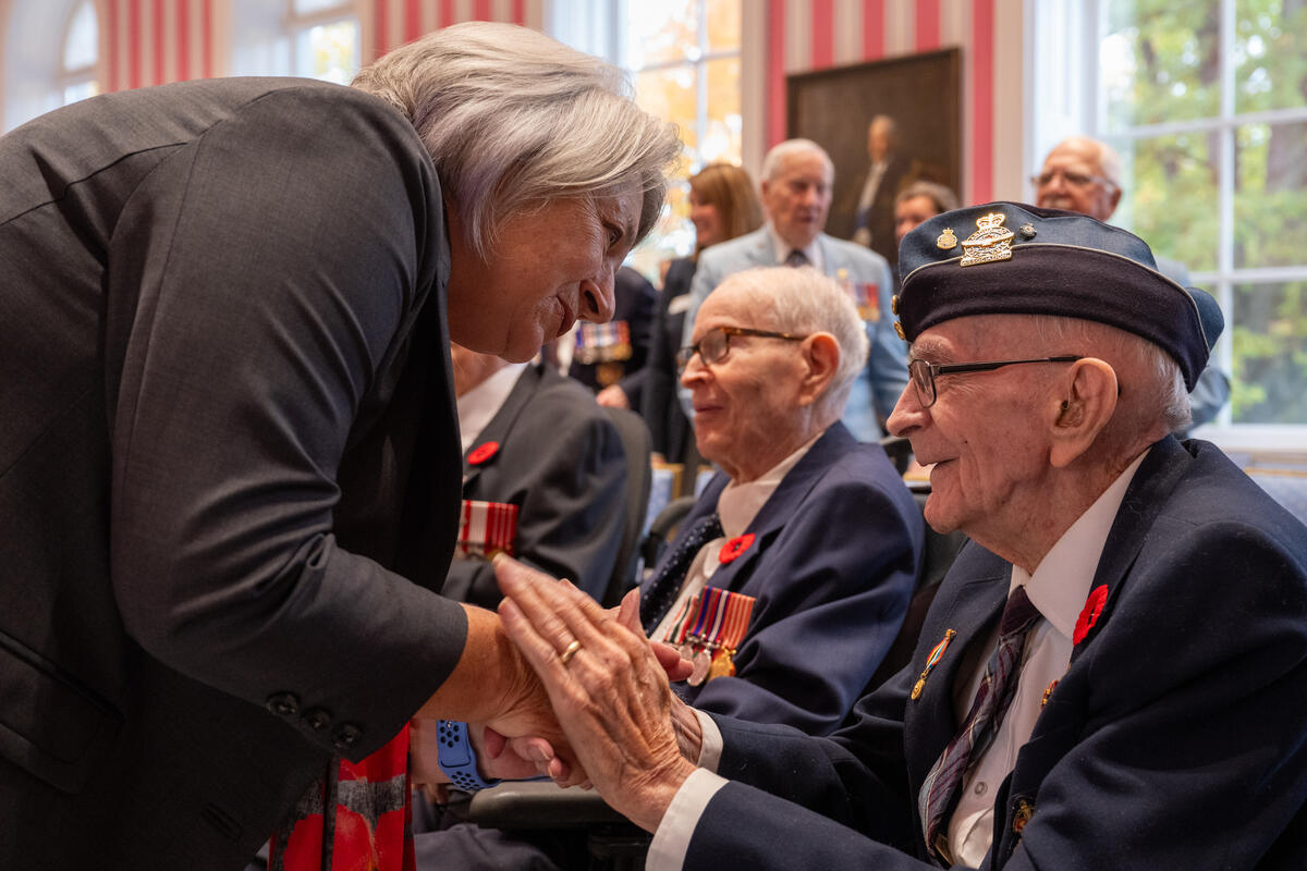 Governor General Mary Simon shakes hands with a veteran