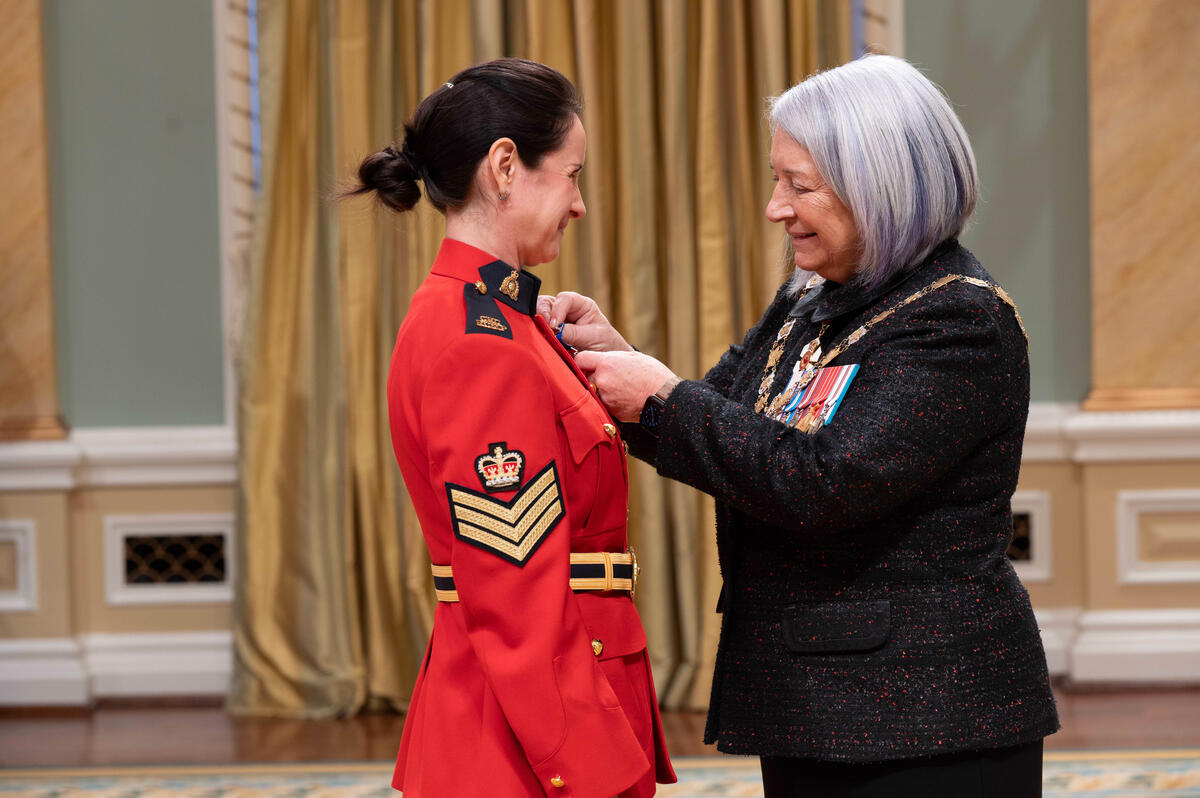 Governor General Mary Simon pins a medal on a member of the Royal Canadian Mounted Police