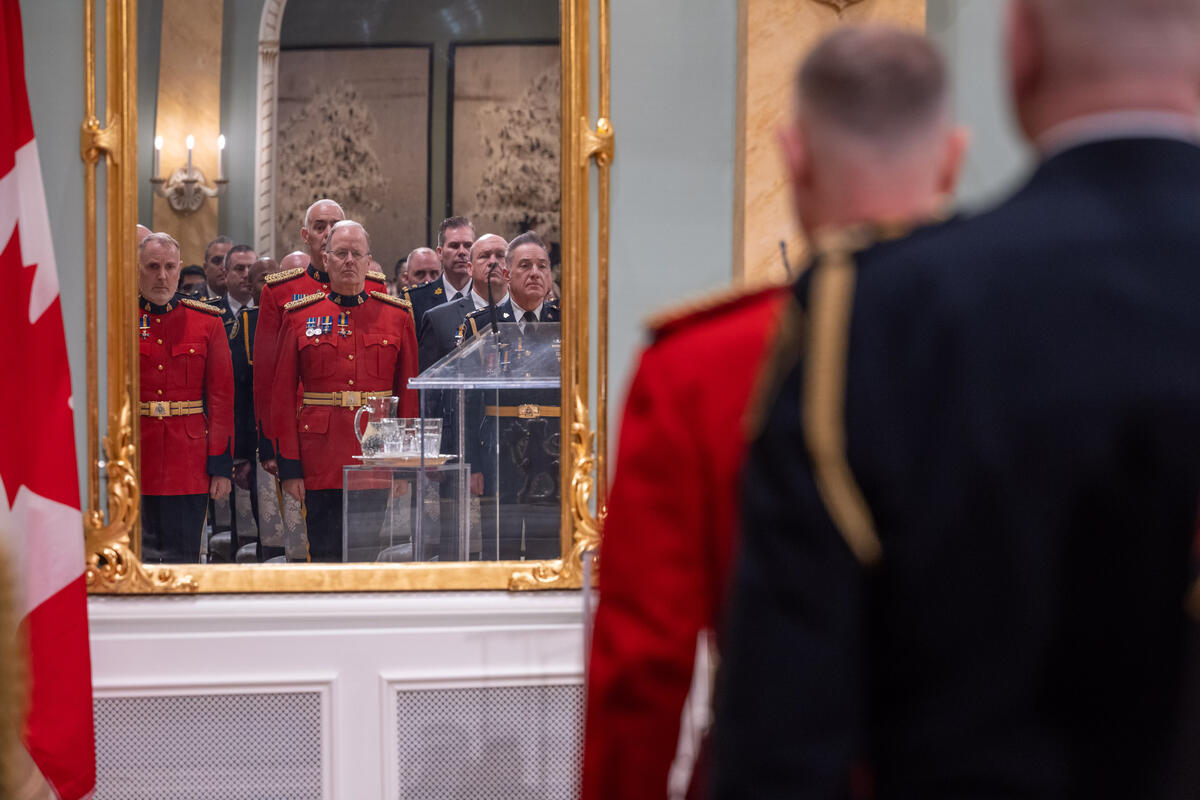 A mirror show the reflection of recipients standing during the ceremony