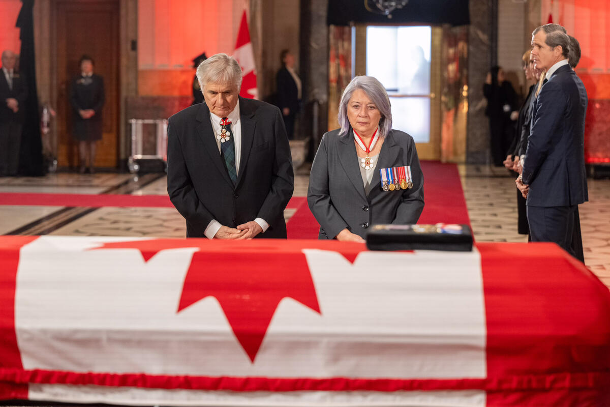 Governor General Mary Simon and Mr. Whit Fraser look and reflect at the casket holding  the Right Honourable Brian Mulroney