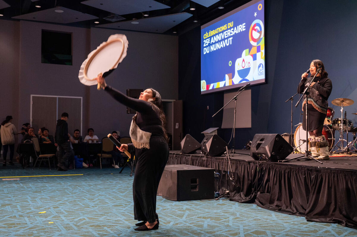Two Indigenous women perform a cultural song and dance