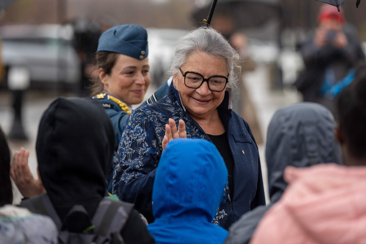 Governor General Mary Simon waves at a child