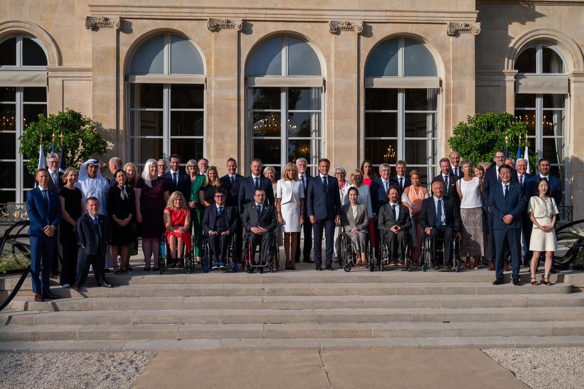 The Governor General Mary Simon, the President Emmanuel Macron and his wife Brigitte Macron stand among a large group of people.