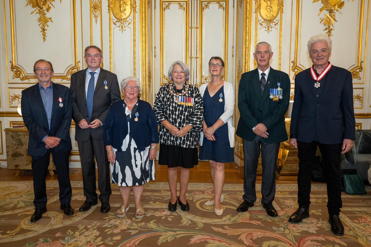 The Governor General Mary Simon stands with a group of people. The group is posing for a photo.