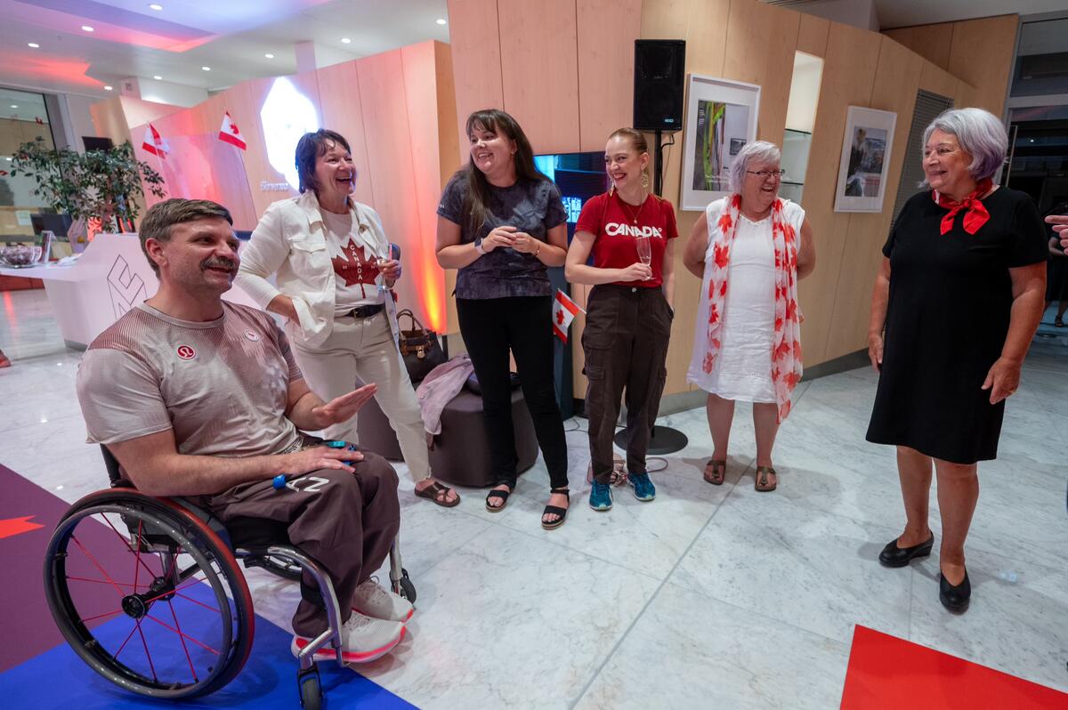 The Governor General of Canada Mary Simon stands in a group of 5 people. They are having a conversation and smiling. 