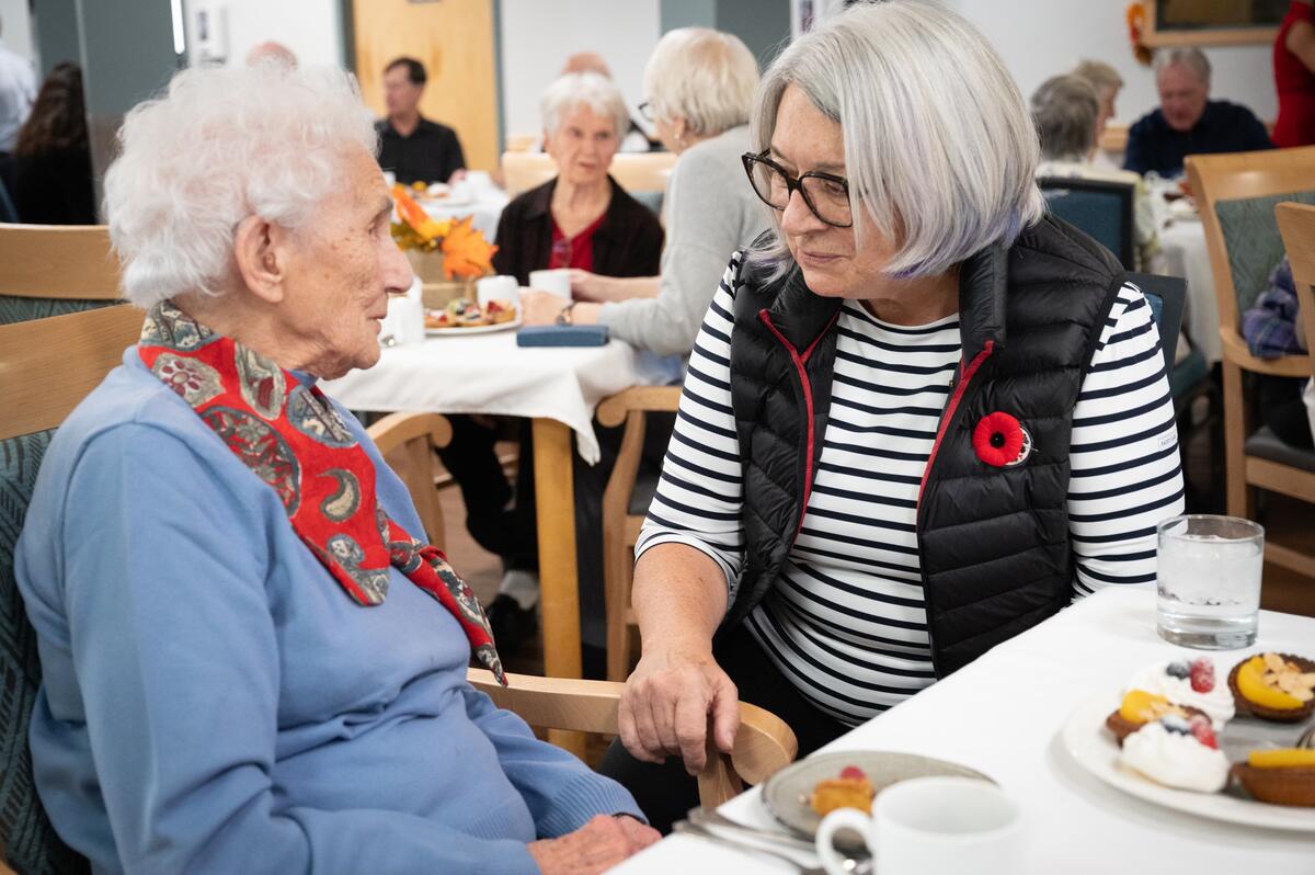 La gouverneure générale discute avec une personne âgée.