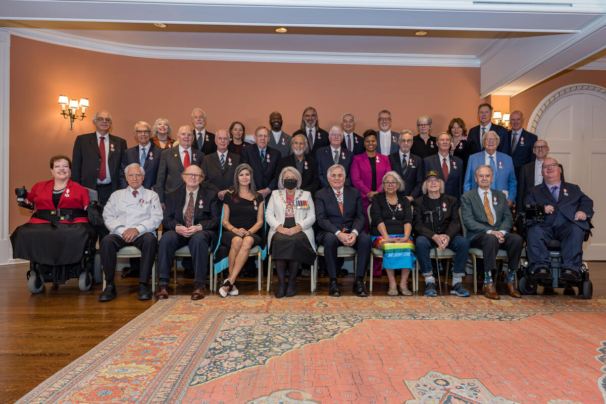 Governor General Mary Simon and Mr. White Fraser sitting in the center of a group photo featuring members of the Order of Canada.