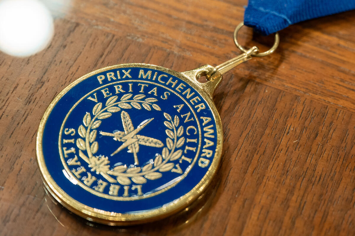 A Michener award on a wooden table. 
