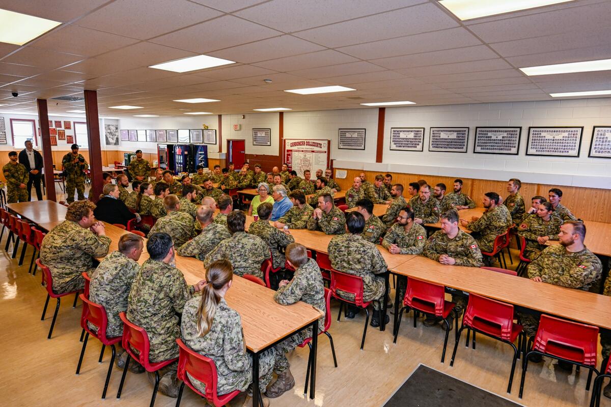 Governor General Mary Simon and Mr. Whit Fraser in a large cafeteria surrounded by members of the Canadian Armed Forces