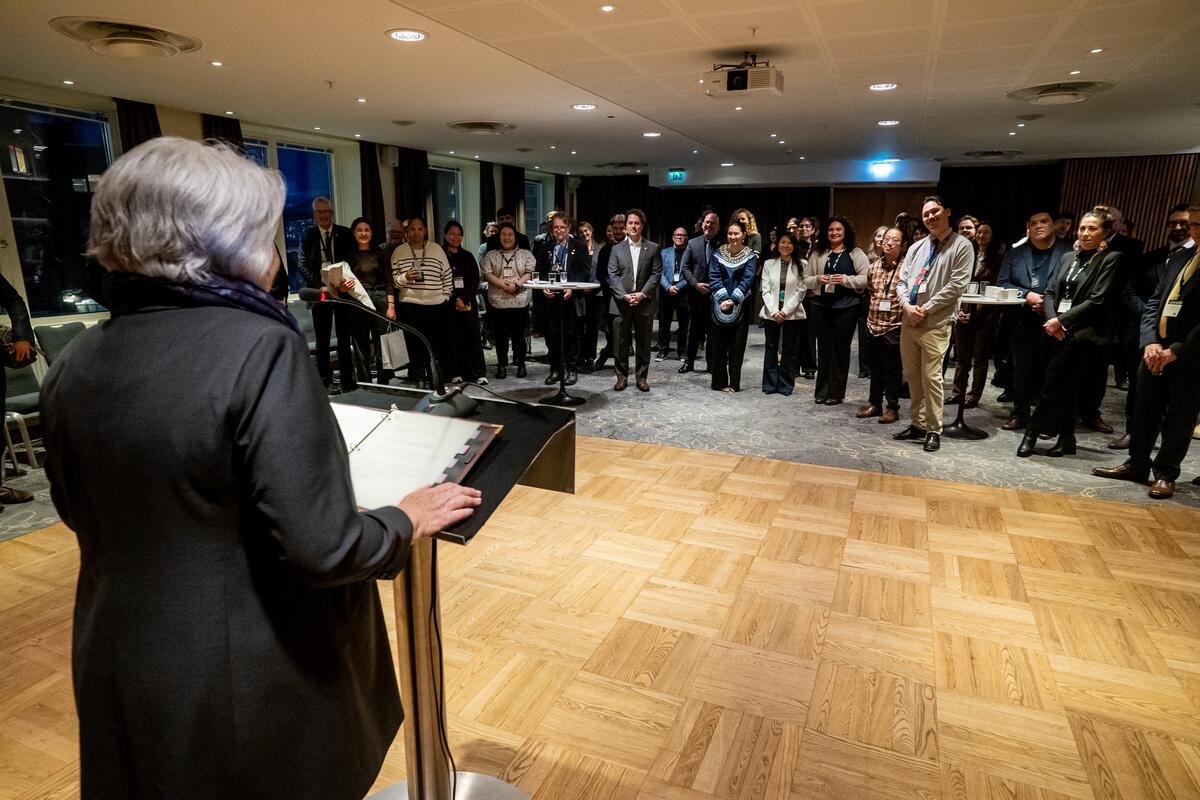 La gouverneure générale debout à un pupitre. La vue est orientée vers la foule debout.