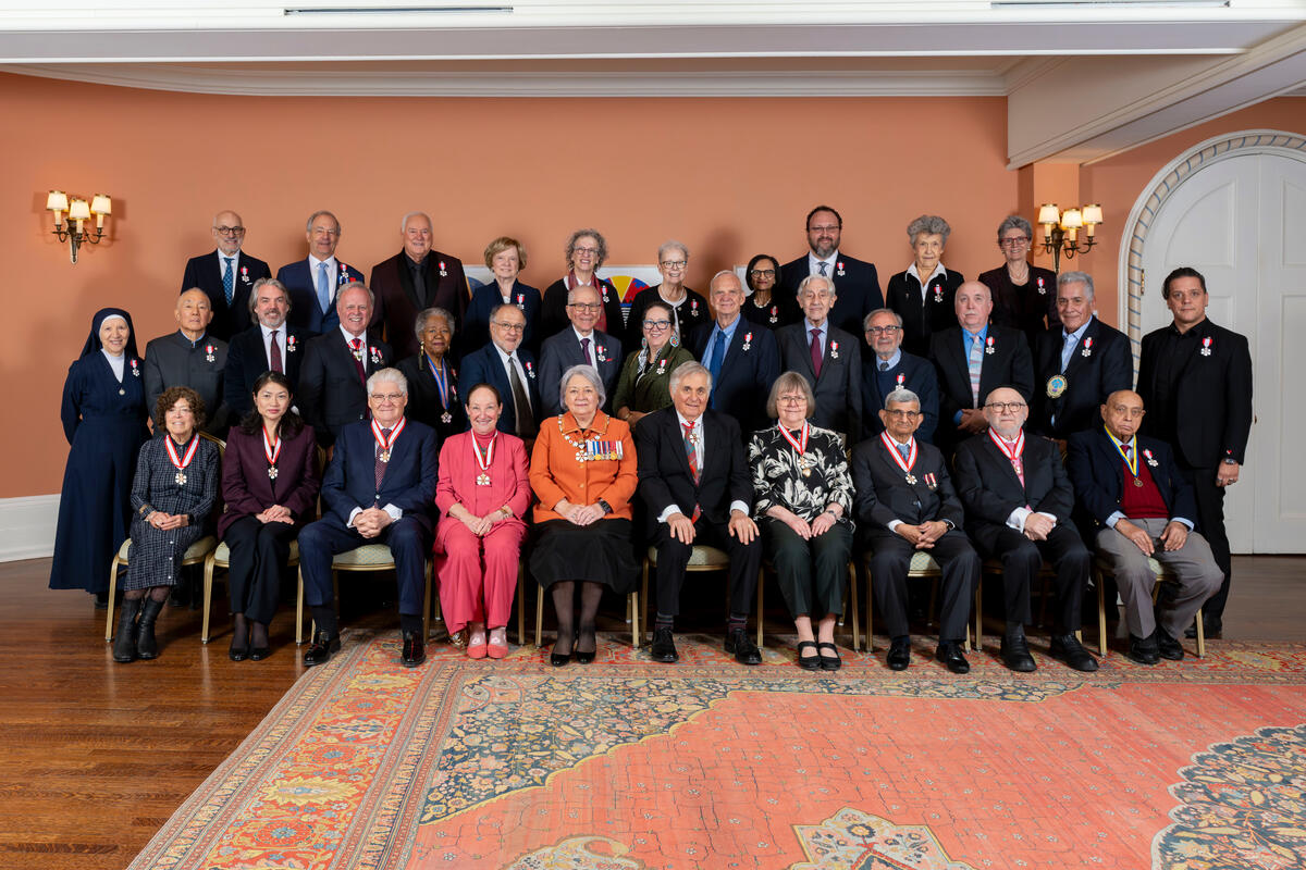 Governor General Mary Simon and Mr. Whit Fraser posing with Honours recipients.