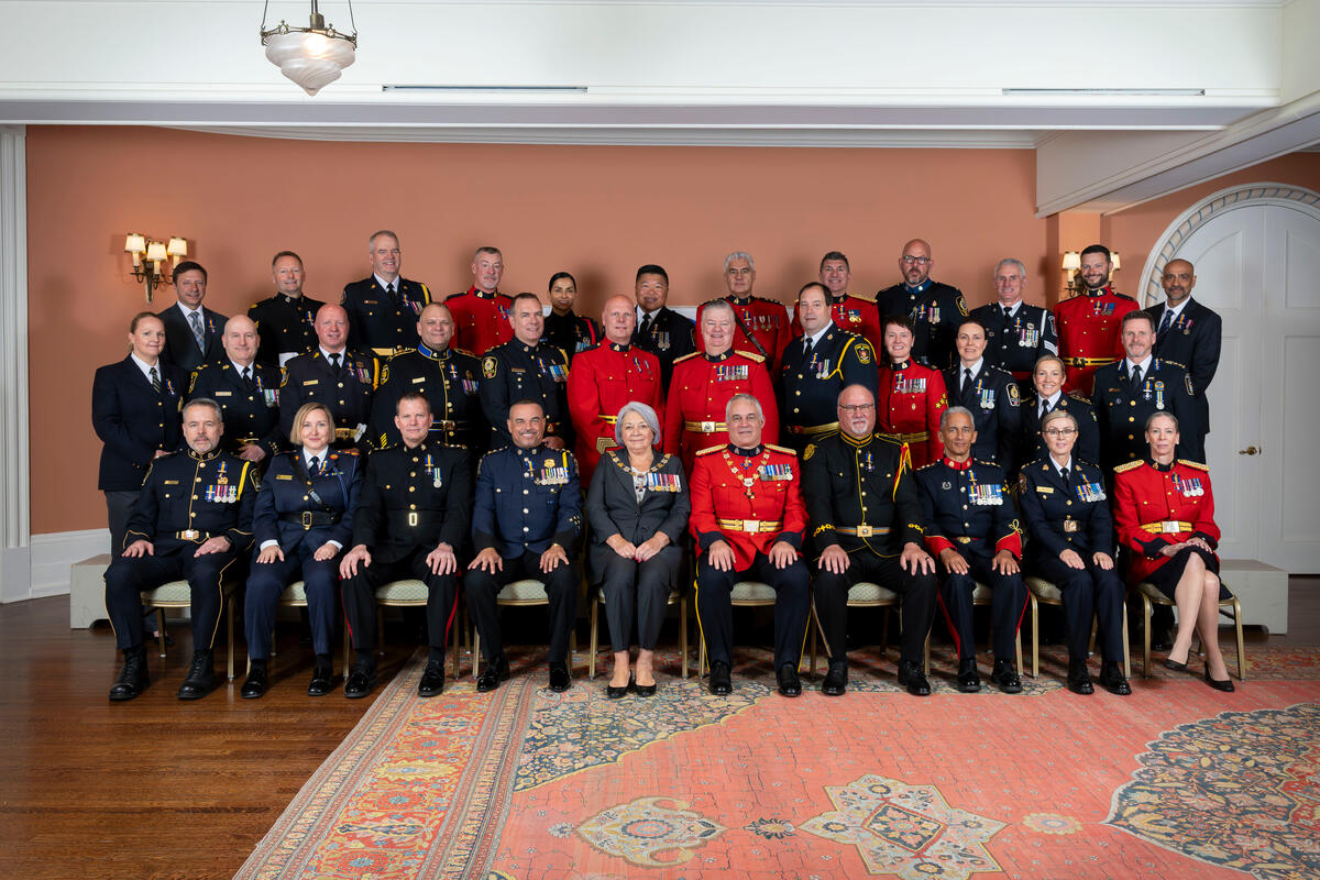 La gouverneure générale Mary Simon pose pour une photo de groupe avec les récipiendaires de l'Ordre du mérite des forces de police.