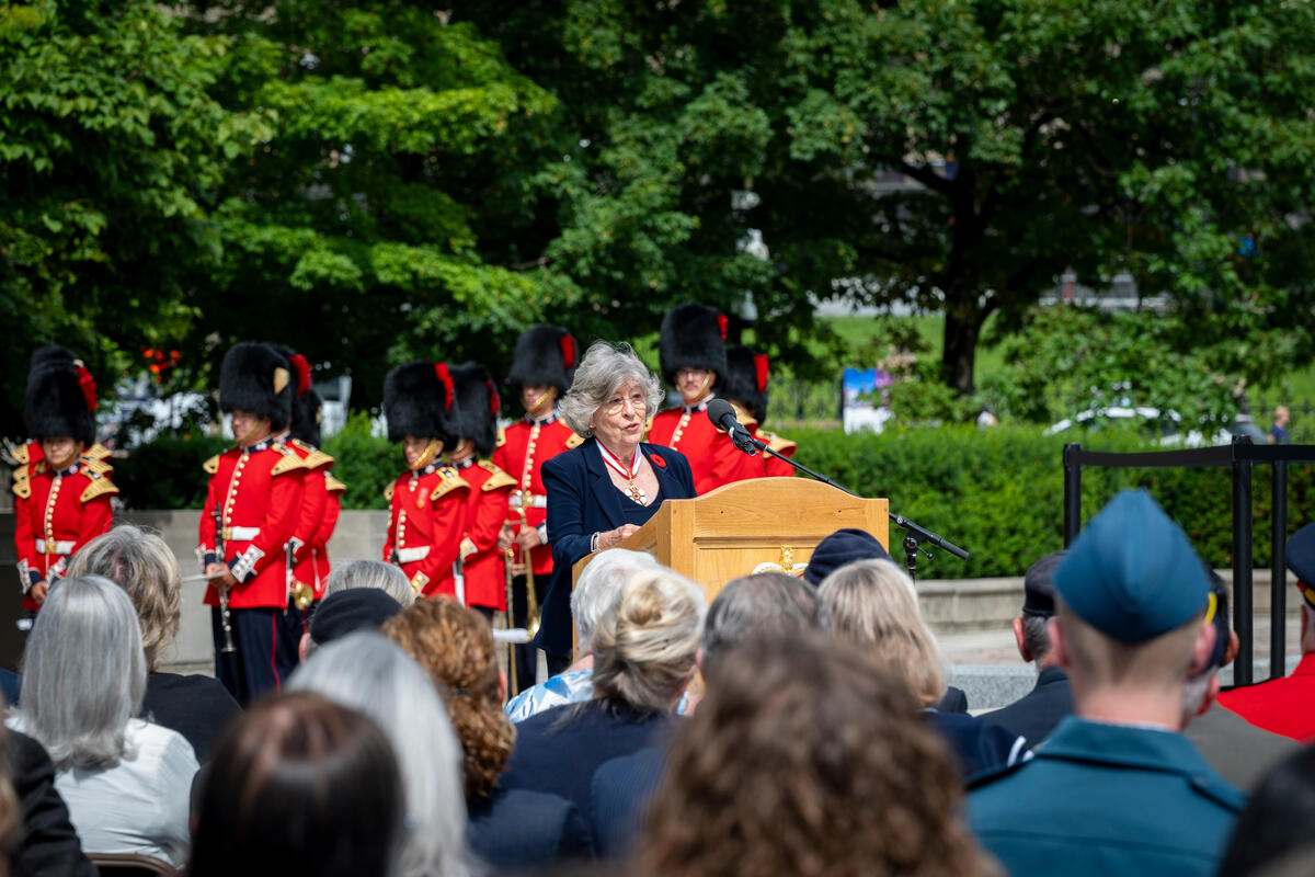 Governor General Arbour speaking at a podium outside the National War Memorial in Ottawa.