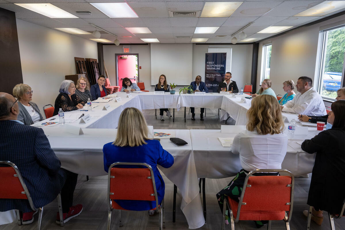 La gouverneure générale Simon et un groupe de personnes assises à des tables rectangulaires en forme de carré.