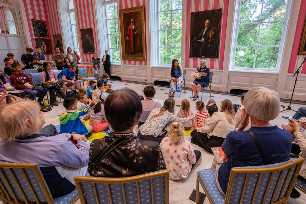 Governor General Mary Simon reading a book to a group of children inside the Tent Room at Rideau Hall.