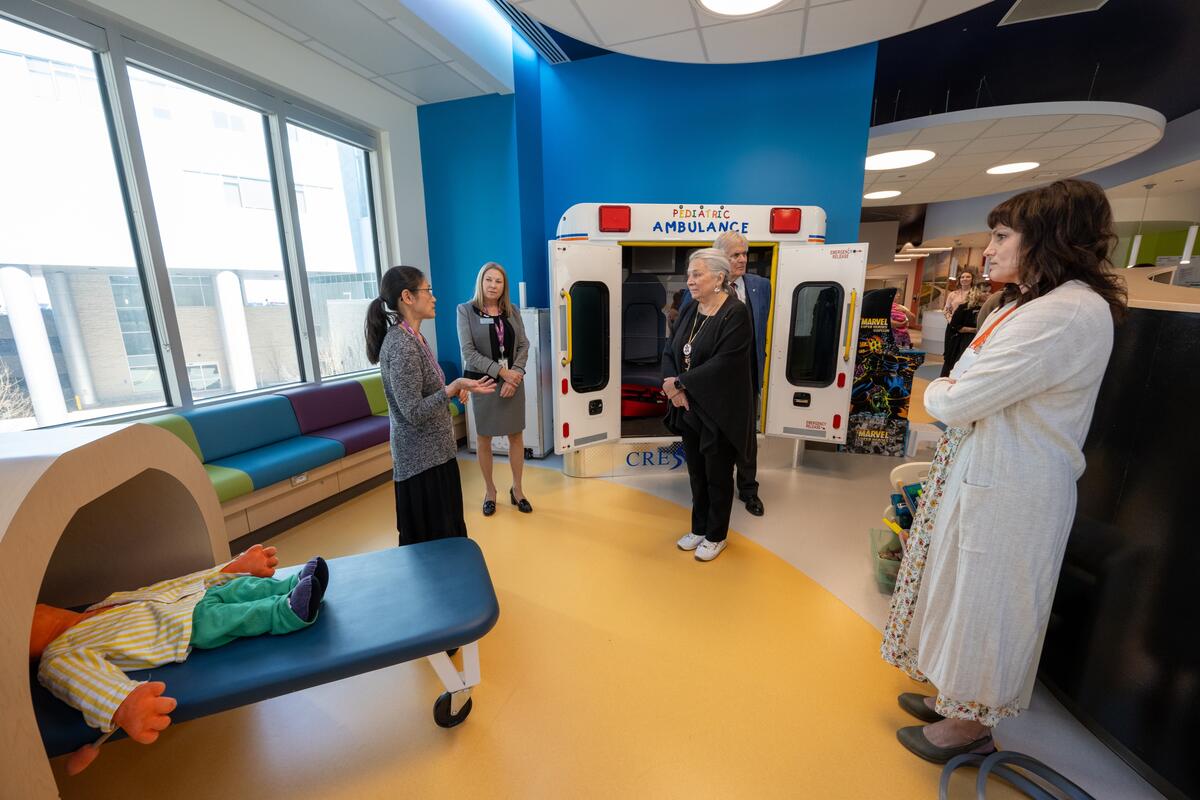 La gouverneure générale Simon debout dans une salle de jeux pour enfants dans un hôpital avec un groupe de personnes.