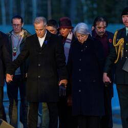 La gouverneure générale Mary Simon, le premier ministre du Canada Mark Carney et le chef du parti de l’opposition officielle du Canada Pierre Poilievre, debout main dans la main. Des personnes se tiennent derrière eux.