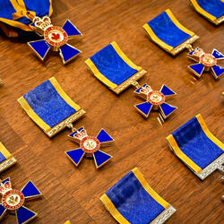 Rangées de médailles de l'Ordre ou du Mérite militaire sur une table.