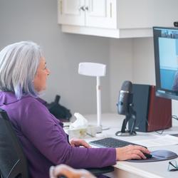 La gouverneure générale Mary Simon est assise à un bureau d'ordinateur, participant à un événement virtuel.