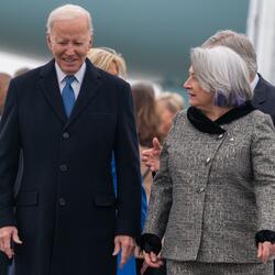 Governor General Simon walks next to U.S President Joe Biden. There is a group of people behind them.