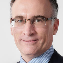 Officer of the Order of Canada - Carl-Éric Aubin. He is wearing a blue shirt and tie with a dark suit coat.