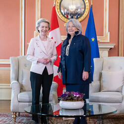 La gouverneure générale Simon se tient à côté de Son Excellence Ursula von der Leyen, présidente de la Commission européenne. Ils sourient à la caméra. En arrière-plan, on retrouve le drapeau canadien et le drapeau européen.