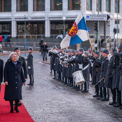 Governor General Simon and President Sauli Niinistö walking down a red carpet. They are inspecting a guard of honour.