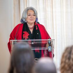 La gouverneure générale est debout sur un pupitre.