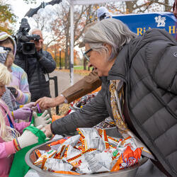 Governor General Marie Simon hands candy to a child in costume