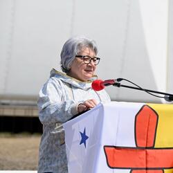 Governor General Mary Simon at at a podium draped in the Nunavut flag