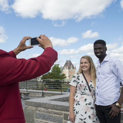  A guide taking a picture of two guests outside of the Citadelle.