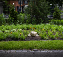 Le jardin des cœurs de Rideau Hall. Trois petites statues en forme de cœur entourées de nombreuses plantes.