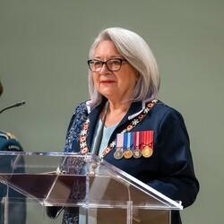 The Governor General is standing at a podium. 