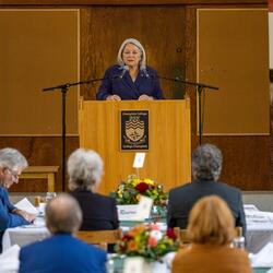 The Governor General is standing at a podium.