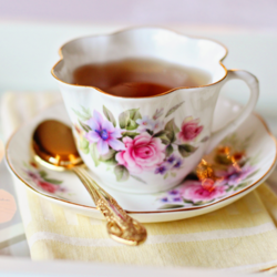 Tasse à thé, soucoupe et cuillère sur une serviette de table.