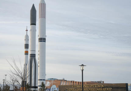 Three rockets are photographed outdoors.  Bottom right, large sign reads ‘The National Space Center’.