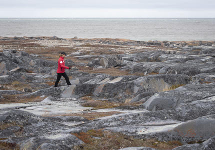 The Governor General is walking over rocky terrain.