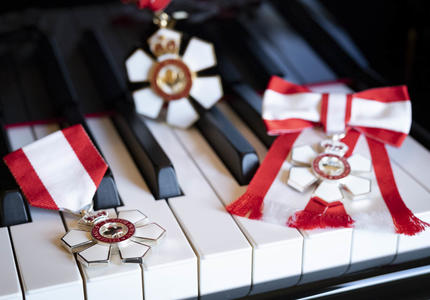 The insignia of the Order of Canada on the keyboard of a piano.