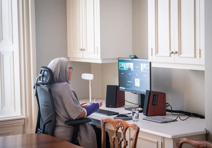 La gouverneure général est assise à un bureau. Elle participe à un chat vidéo sur son ordinateur. 