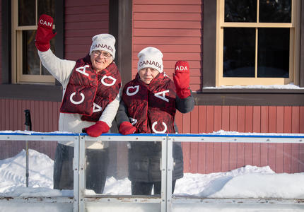 Their Excellencies waving to the camera, wearing official Olympic mittens, scarves and toques.