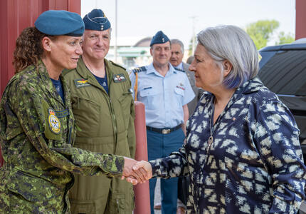 La gouverneure générale Marie Simon serre la main d'un membre des Forces armées canadiennes