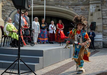 La gouverneure générale Marie Simon assiste à un spectacle culturel. Un enfant autochtone danse.