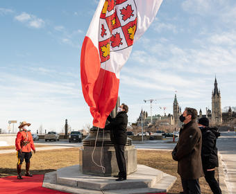 L'administrateur lève un drapeau du nouvel emblème héraldique de la Cour suprême du Canada.