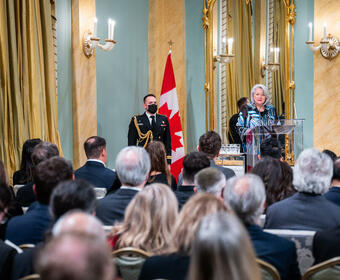 Governor General Simon is addressing a crowd in the Ballroom at Rideau Hall.