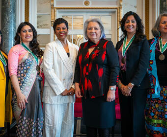La gouverneure générale Simon se tient debout à côté de cinq autres femmes.