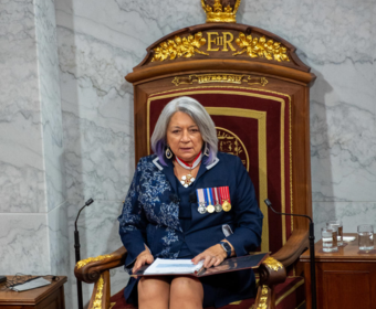 Governor General Mary Simon reads the Throne speech in the Senate. She is wearing a navy blue ensemble.