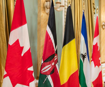 National flags of Kenya, Belgium and Lesotho are lined up in a row between two Canadian flags.