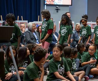 Governor General Mary Simon sits while students walk in front of her